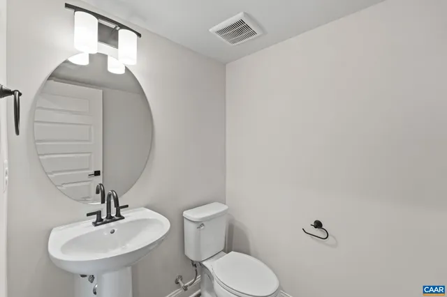a bathroom with a toilet a sink and mirror