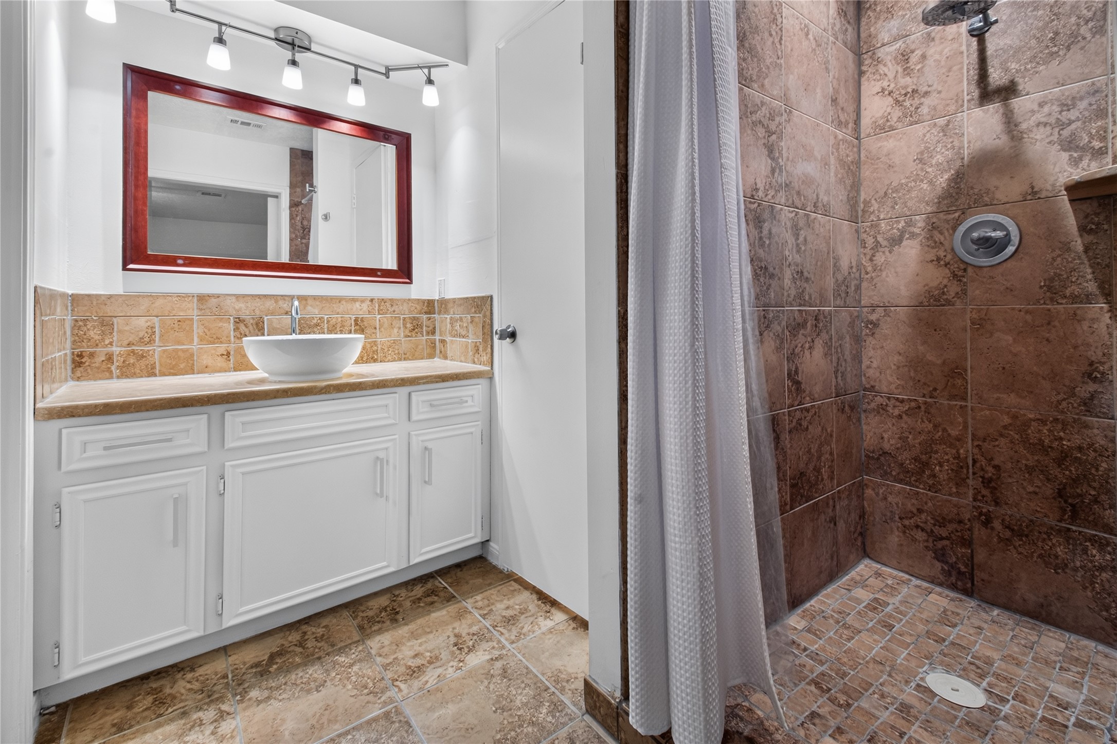 25223 Lynbriar Lane Spring, TX 77373 - Photo 14 of 32 The primary bathroom features a walk-in shower, updated vessel sink, and a large vanity with plenty of counter space for your daily routine.