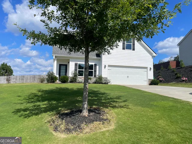 a view of a house with backyard and a tree
