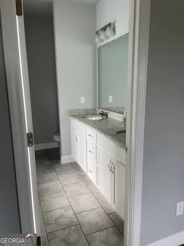 a spacious bathroom with a granite countertop sink and a mirror