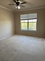 an empty room with a window and a ceiling fan