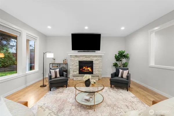 a living room with furniture a flat screen tv and a fireplace