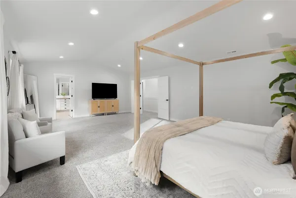 a spacious bedroom with a bed and a flat screen television