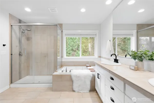 a bathroom with a tub sink and mirror