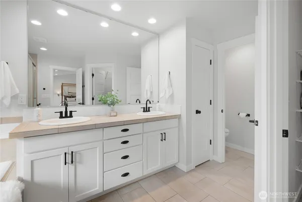 a bathroom with double sink and a mirror