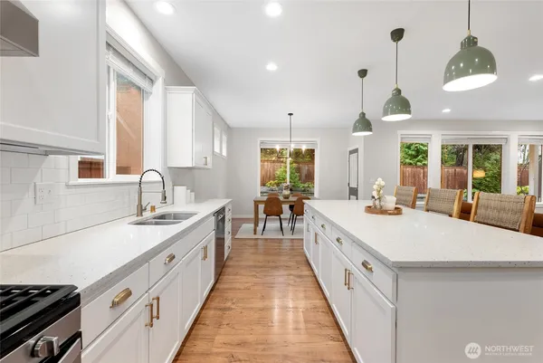 a large kitchen with kitchen island a stove a sink a center island and windows