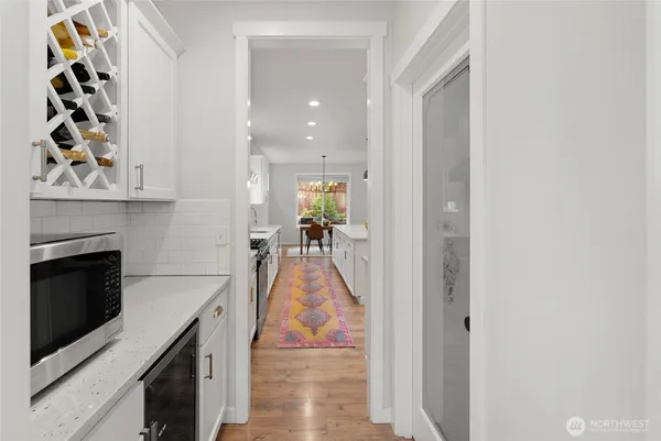 a hallway with a stove and a kitchen view