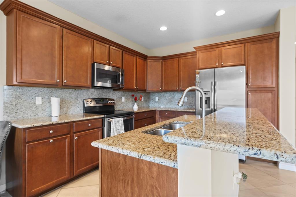 5224 Southwest 77th Way Davie, FL 33328 - Photo 31 of 43 a kitchen with granite countertop a sink stove and cabinets