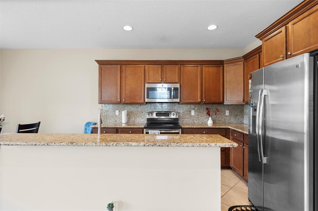 5224 Southwest 77th Way Davie, FL 33328 - Photo 32 of 43 a kitchen with stainless steel appliances granite countertop a refrigerator a stove top oven a sink and dishwasher