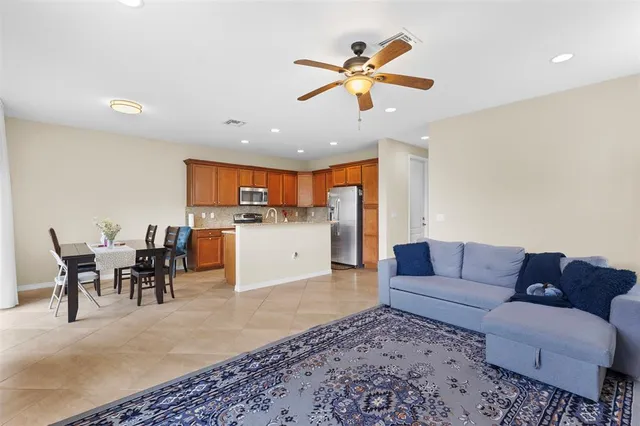 a living room with furniture kitchen view and a chandelier