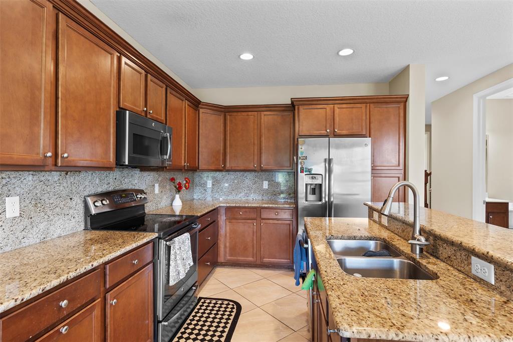 5224 Southwest 77th Way Davie, FL 33328 - Photo 6 of 43 a kitchen with stainless steel appliances granite countertop a sink stove and cabinets