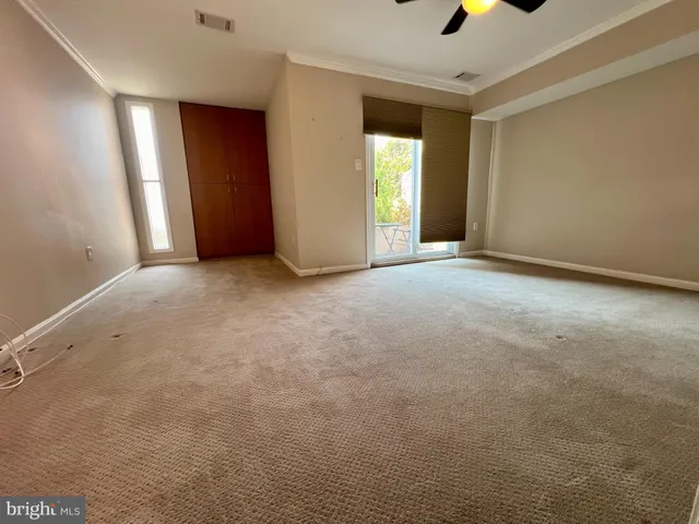 an empty room with windows and cabinet