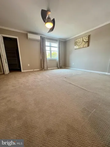 a view of an empty room with chandelier and window