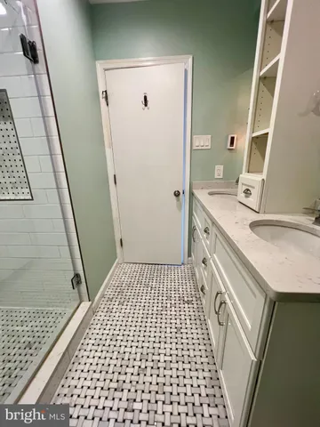 a bathroom with a sink a toilet a mirror and shower
