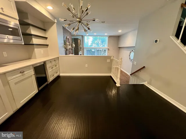 a view of a kitchen with a sink and dishwasher with wooden floor