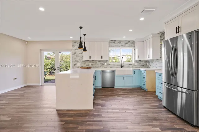 a kitchen with a refrigerator a sink and cabinets