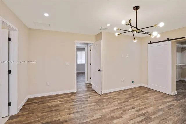 a view of empty room with wooden floor and ceiling fan