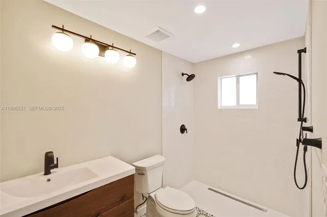 a bathroom with a toilet sink shower and mirror