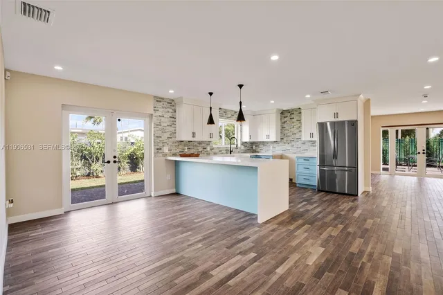 a large kitchen with a large counter top and stainless steel appliances