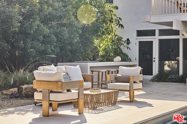 a roof deck with table and chairs and potted plants