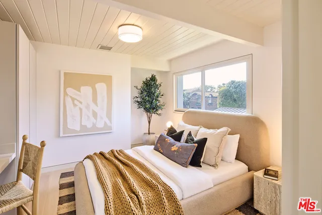 a bedroom with a bed and a painting on the wall