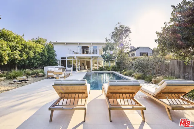 a view of a patio with couches table and chairs and potted plants