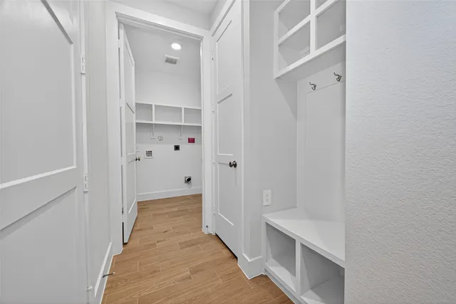 a view of a hallway with wooden floor and closet