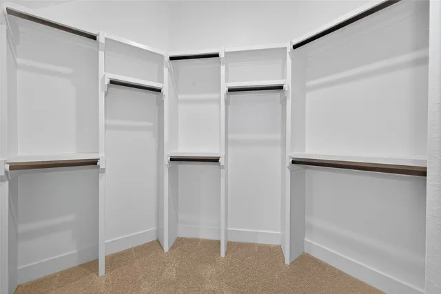 a view of walk in closet with empty racks