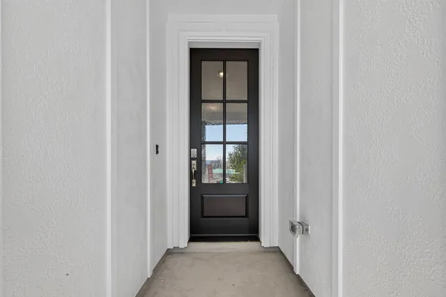 a view of a hallway with wooden floor and a bathroom
