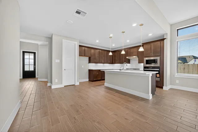 a view of kitchen with kitchen island a sink stainless steel appliances and cabinets