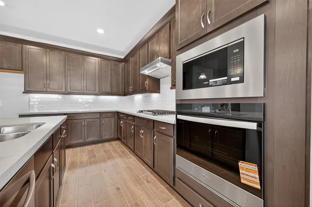 a kitchen with stainless steel appliances granite countertop a stove microwave and sink