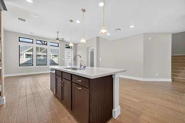 a kitchen with a sink cabinets and wooden floor