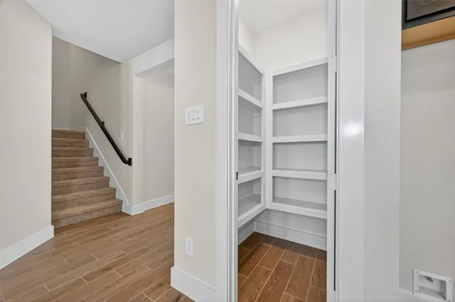 a view of a hallway with wooden floor and entryway