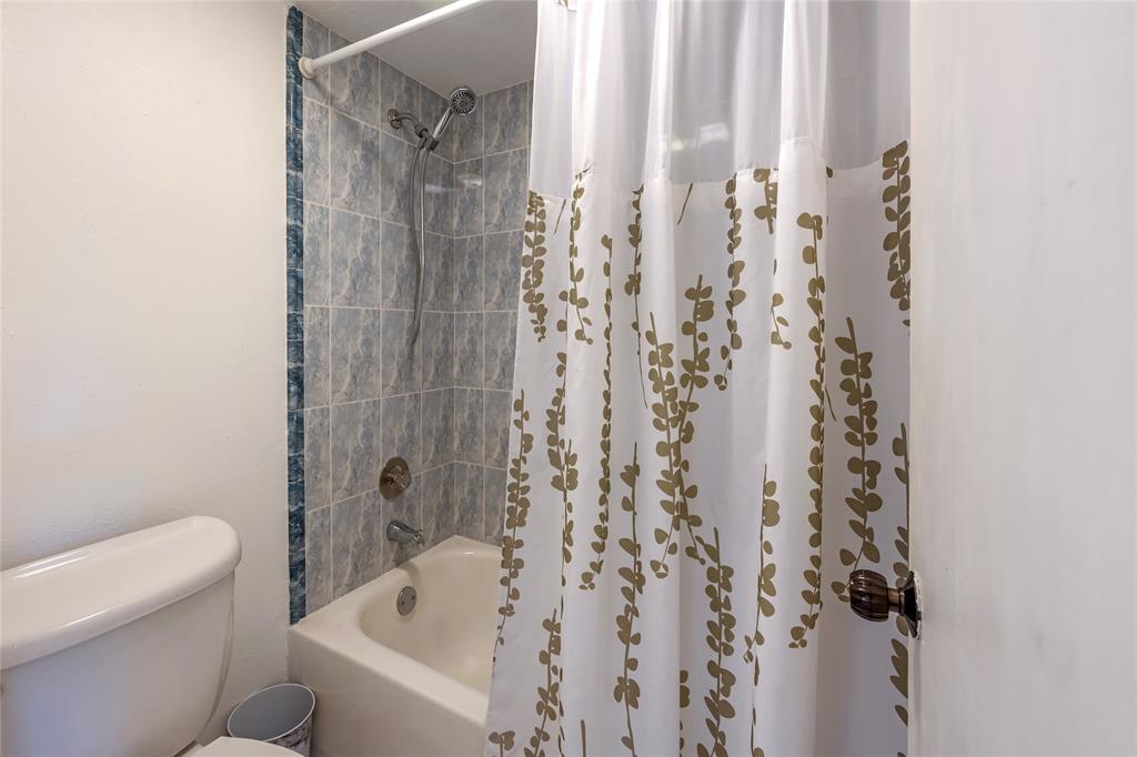 3774 Inverrary Boulevard, Unit 104P Fort Lauderdale, FL 33319 - Photo 19 of 22 a bathroom with a shower curtain and a toilet