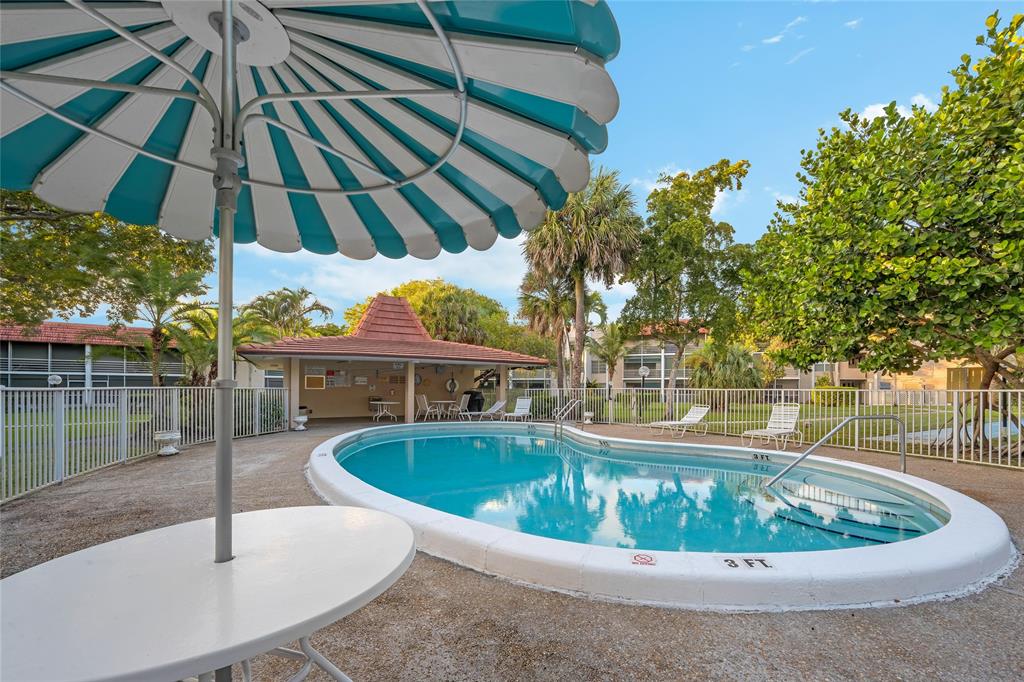 3774 Inverrary Boulevard, Unit 104P Fort Lauderdale, FL 33319 - Photo 3 of 22 a view of a swimming pool with a patio