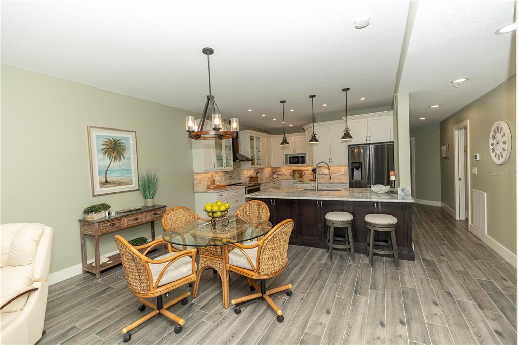 9203 Griggs Road, Unit D302 Englewood, FL 34224 - Photo 11 of 73 a dining room with wooden floor a chandelier a wooden table and chairs