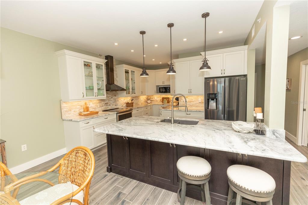 9203 Griggs Road, Unit D302 Englewood, FL 34224 - Photo 12 of 73 a kitchen with a table chairs sink and cabinets