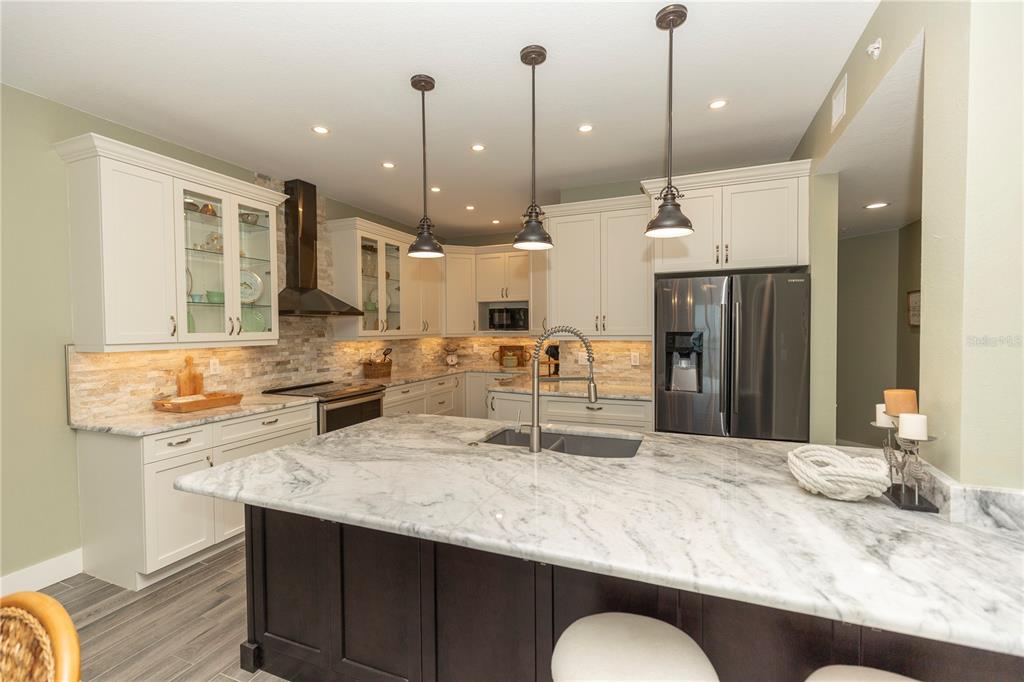 9203 Griggs Road, Unit D302 Englewood, FL 34224 - Photo 14 of 73 a kitchen with kitchen island a sink stove and refrigerator