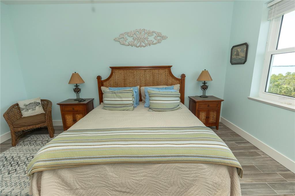 9203 Griggs Road, Unit D302 Englewood, FL 34224 - Photo 20 of 73 a bedroom with a bed and a painting on the wall