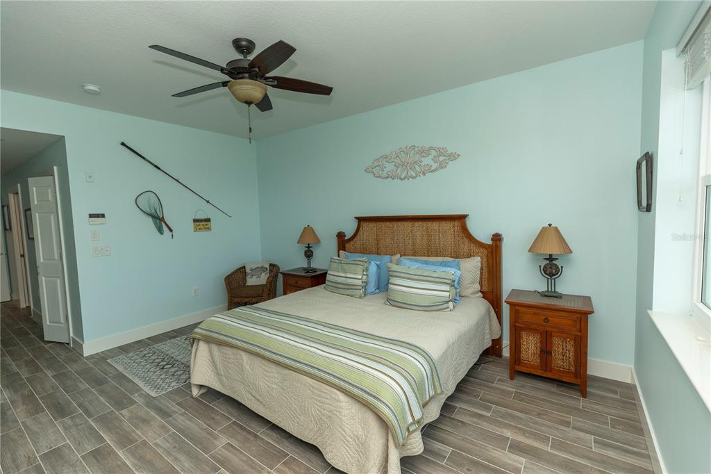 9203 Griggs Road, Unit D302 Englewood, FL 34224 - Photo 21 of 73 a bedroom with a bed and a chandelier