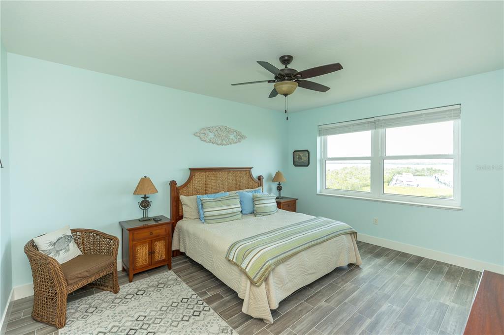 9203 Griggs Road, Unit D302 Englewood, FL 34224 - Photo 26 of 73 a bedroom with a bed a chandelier and a window
