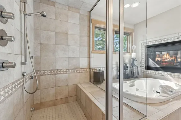 a bathroom with a tub a sink and glass door shower