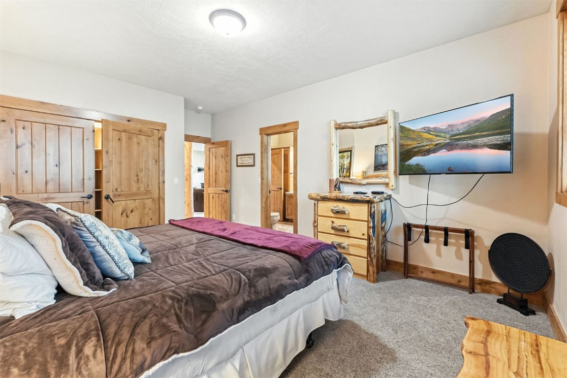 1730 Red Hawk Road Silverthorne, CO 80498 - Photo 27 of 50 a bedroom with a bed and dresser with wooden floor