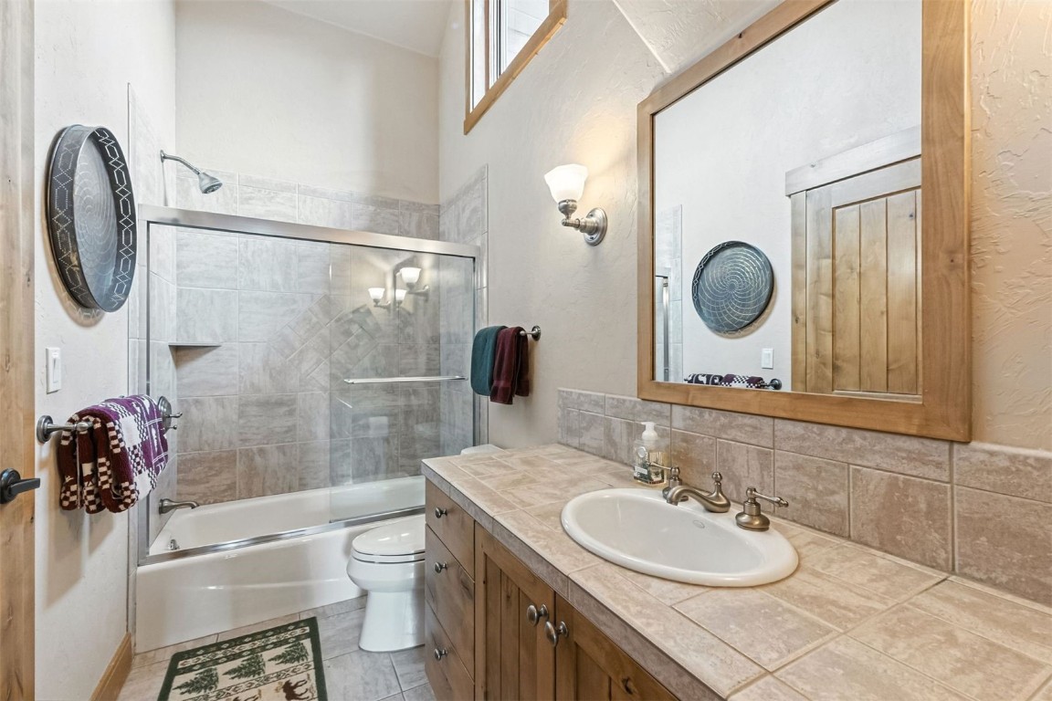 1730 Red Hawk Road Silverthorne, CO 80498 - Photo 37 of 50 a bathroom with a granite countertop sink a toilet and a mirror
