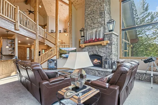 a living room with furniture a fireplace and a floor to ceiling window