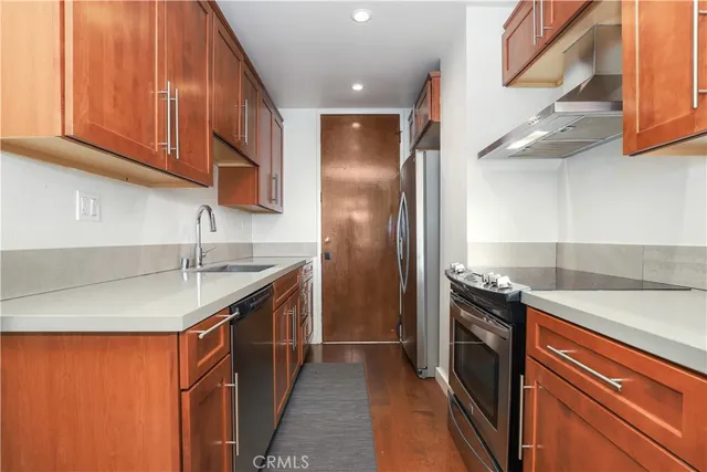 a kitchen with stainless steel appliances granite countertop a sink and a refrigerator