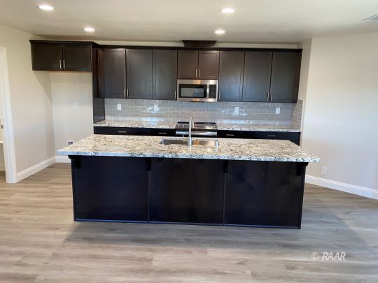 1629 Mayo Street Ridgecrest, CA 93555 - Photo 8 of 25 a kitchen with kitchen island granite countertop wooden cabinets and stainless steel appliances