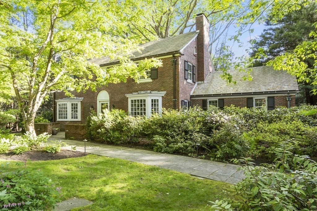 a front view of a house with a yard and trees