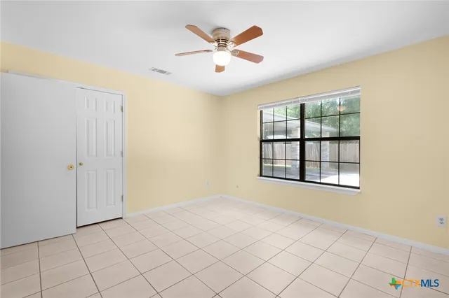 a view of an empty room with window and cabinet