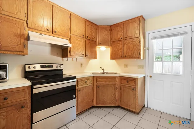 a kitchen with cabinets appliances and a window